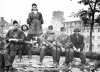 thumbs the day after last souvenir photo before marching off to captivity after the uprising surrender on november 2 1944 with rubbles of the prudential skyscraper as a backdrop Polish Błyskawica SMG