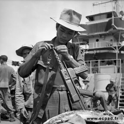 Vietnamese soldier in French service working on his MAT-49 SMG.