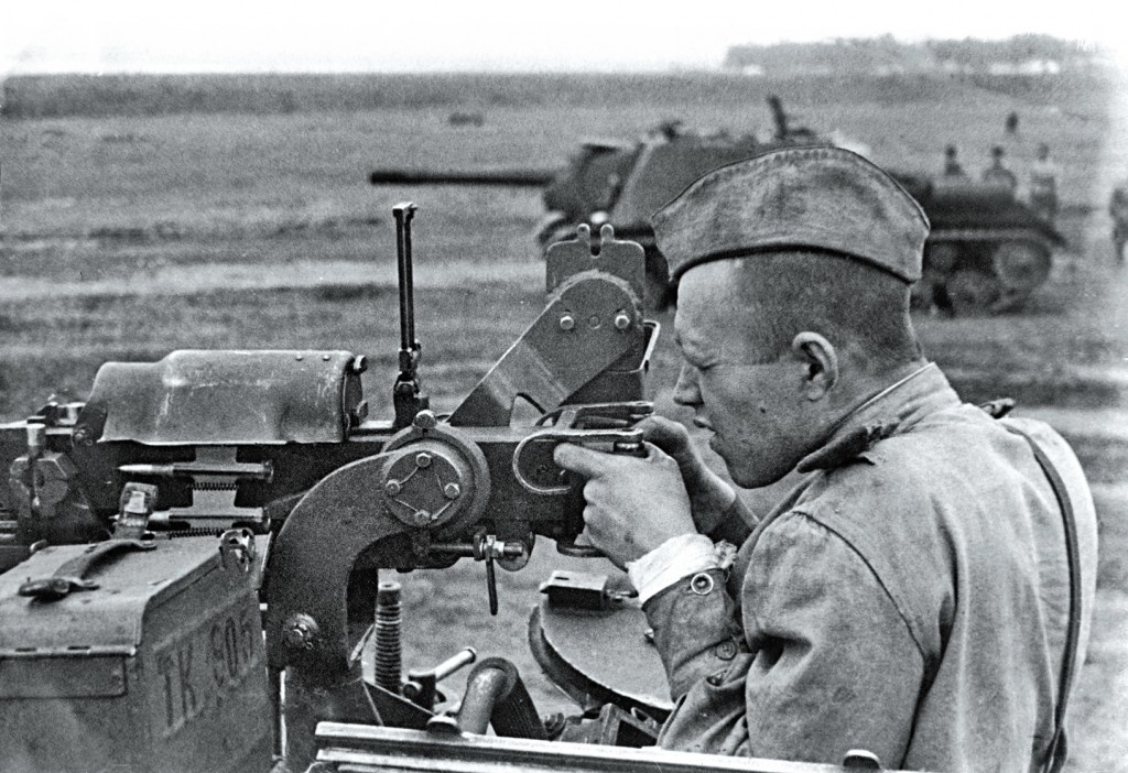 Soviet tanker firing a DShK heavy machine gun from an ISU-152 tank destroyer.