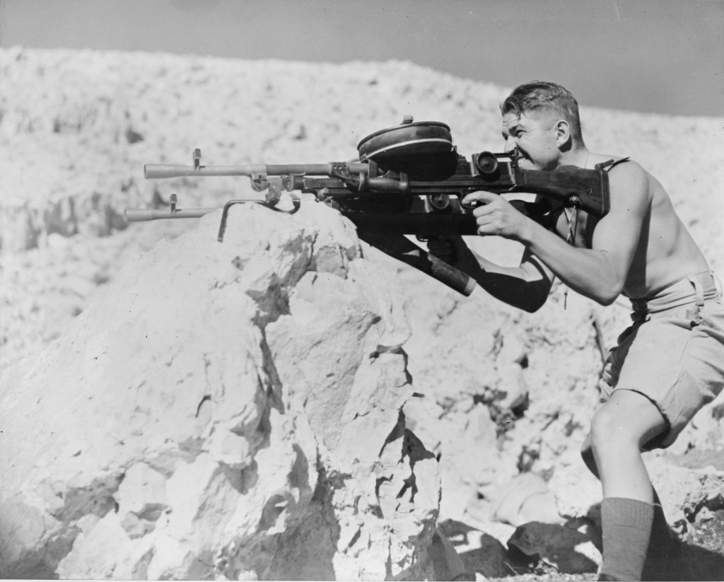 New Zealand trooper firing a pair of Bren guns with 100-round drum mags