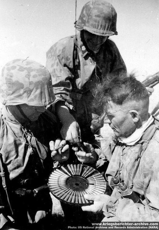 Waffen SS soldiers investigating a captured DP-28 LMG pan magazine